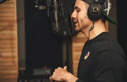 Un hombre graba su voz con un micrófono en un estudio.